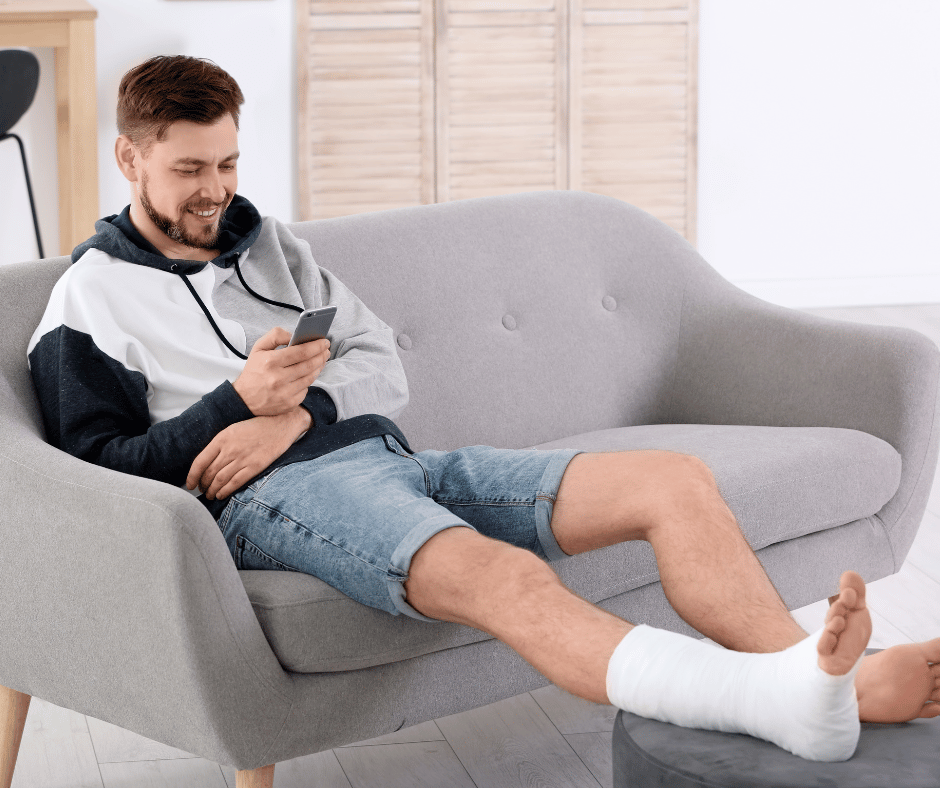 Man with injured leg posting on social media using his smart phone.